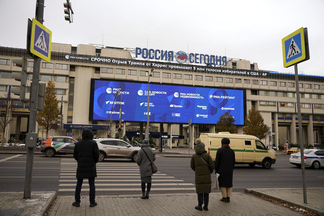 Pedestrians stand at the crossing in front of the Rossiya Segodnya International Media Group building with a running news line about the US elections, top, in Moscow, Russia, on November 6, 2024.