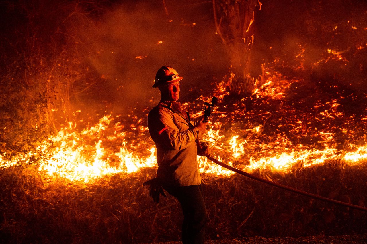 A firefighter prepares to douse flames while battling the Mountain Fire in Santa Paula, California on November 6.