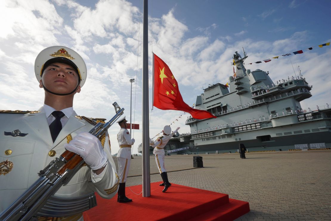 Chinese honor guard raise the Chinese flag during the commissioning ceremony of China's conventionally powered Shandong aircraft carrier at a naval port in Sanya, south China's Hainan Province, on December 17, 2019.