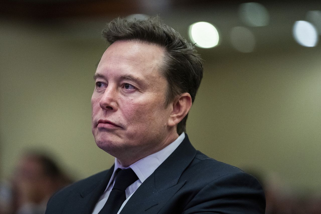 Elon Musk listens as President-elect Donald Trump speaks, during a meeting with the House GOP conference in Washington, DC, on November 13, 2024.