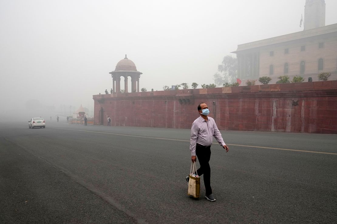 A man walks to work as a thick layer of smog coats New Delhi on November 18, 2024.