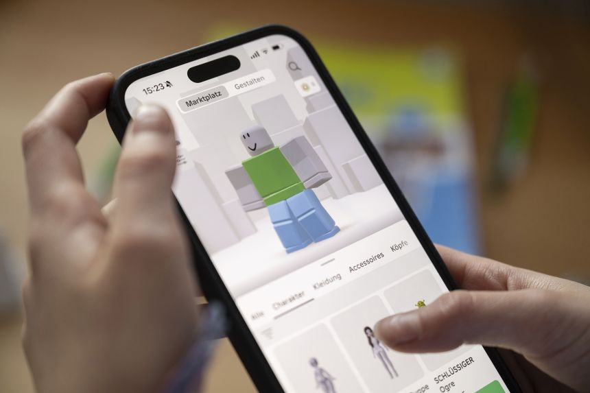 Bir kız akıllı telefonunda Roblox kullanıyor. Roblox, çocukları korumak için kullanıcıların yaşlarını doğrulamak amacıyla yeni çalışmalar yürütüyor.