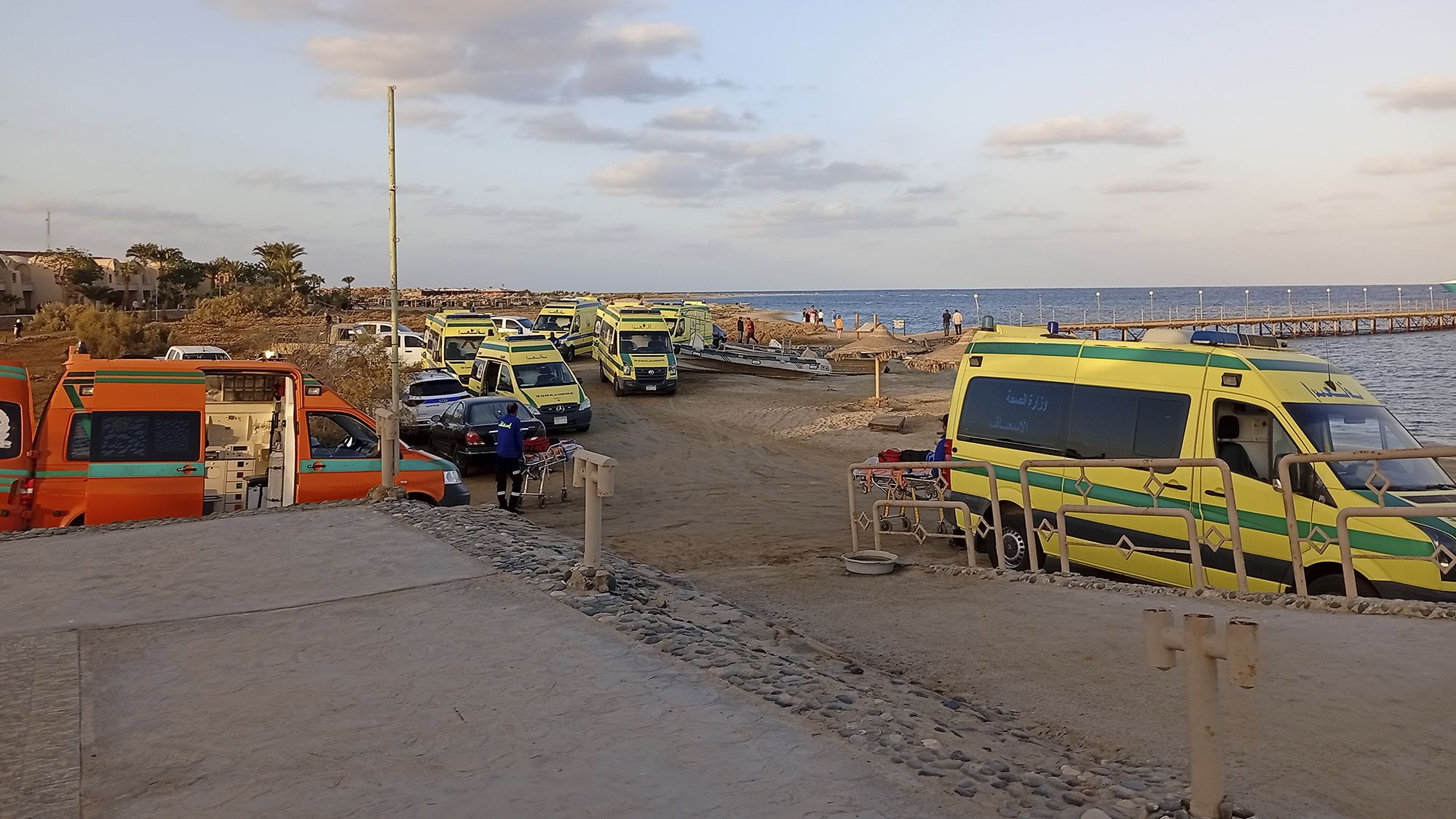 Rescuers and ambulance cars wait on the beach for possible survivors after a boat sank at a harbor in Marsa Alam, Egypt.