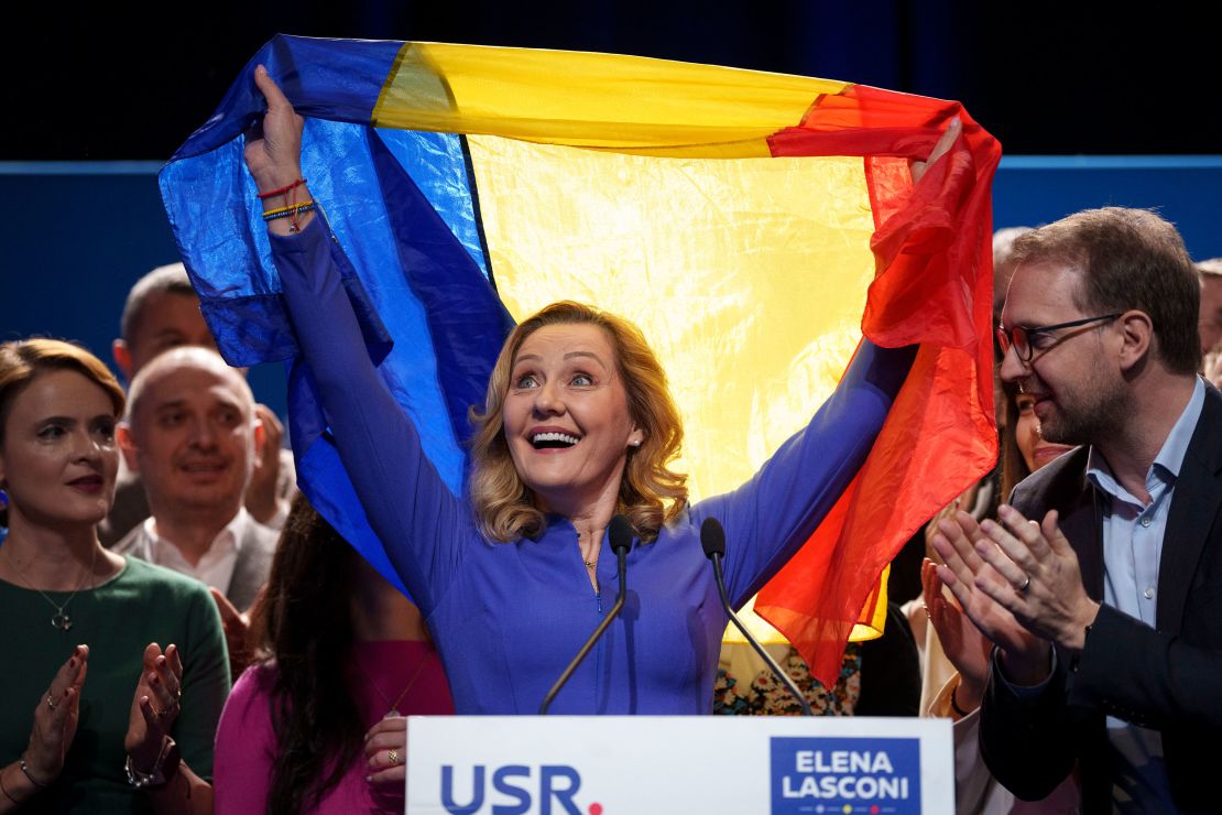 Romanian presidential candidate Elena Lasconi holds Romania's flag at the end of a meeting with supporters in Bucharest, Romania, on November 25 after making it to the runoff.