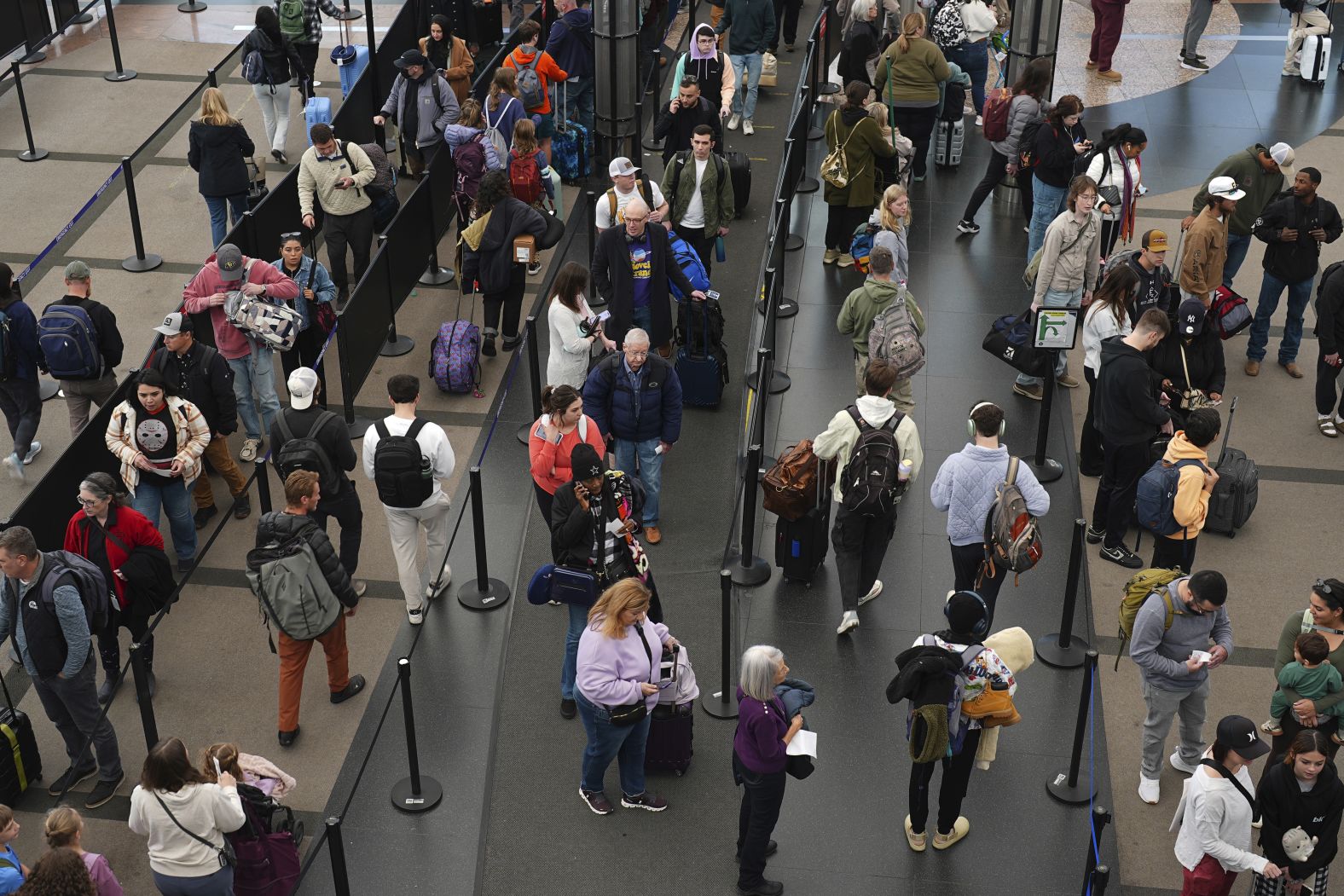 Travelers wait in line to pass through a security checkpoint Tuesday at Denver International Airport.