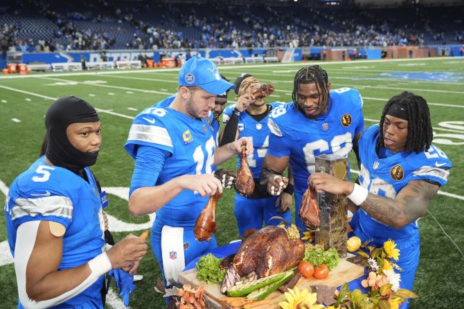 From left, Detroit Lions running back David Montgomery, quarterback Jared Goff, wide receiver Amon-Ra St. Brown, linebacker Al-Quadin Muhammad and running back Jahmyr Gibbs celebrate with turkey after the Lions defeated the Chicago Bears 23-20 in a <a href=