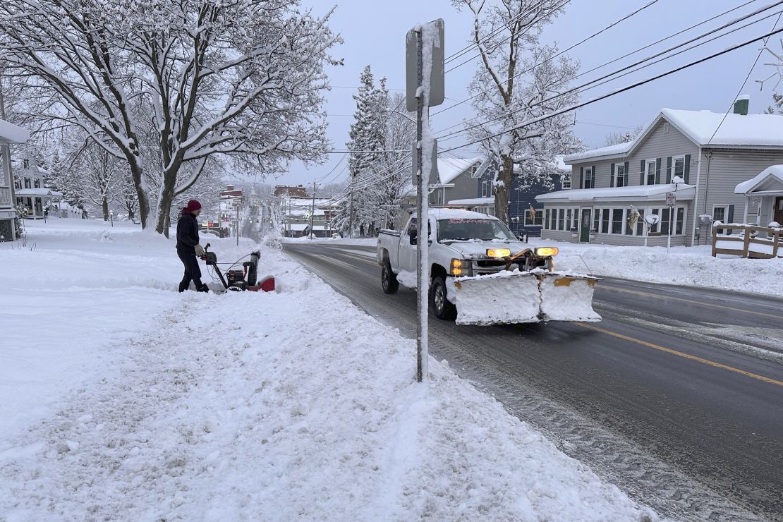 A person clears snow from the sidewalk in Lowville, New York on Saturday.