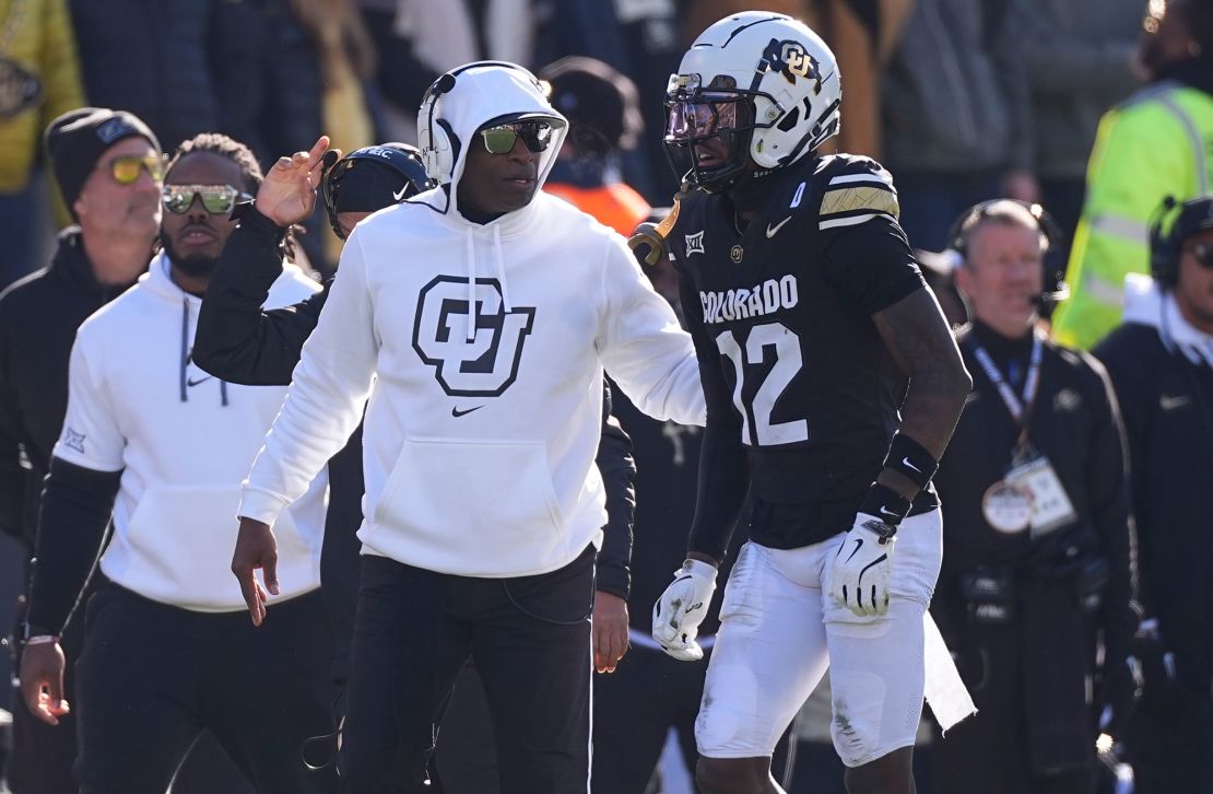 Colorado head coach Deion Sanders speaks with Travis Hunter during a game in November.