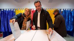 A man and a woman post their votes in the country's parliamentary elections, in Bucharest, Romania, Sunday, Dec. 1, 2024. (AP Photo/Andreea Alexandru)