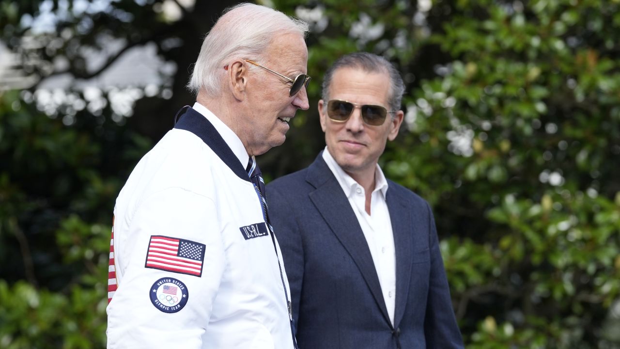 President Joe Biden, wearing a Team USA jacket and walking with his son Hunter Biden, heads toward Marine One on the South Lawn of the White House in Washington, July 26, 2024.