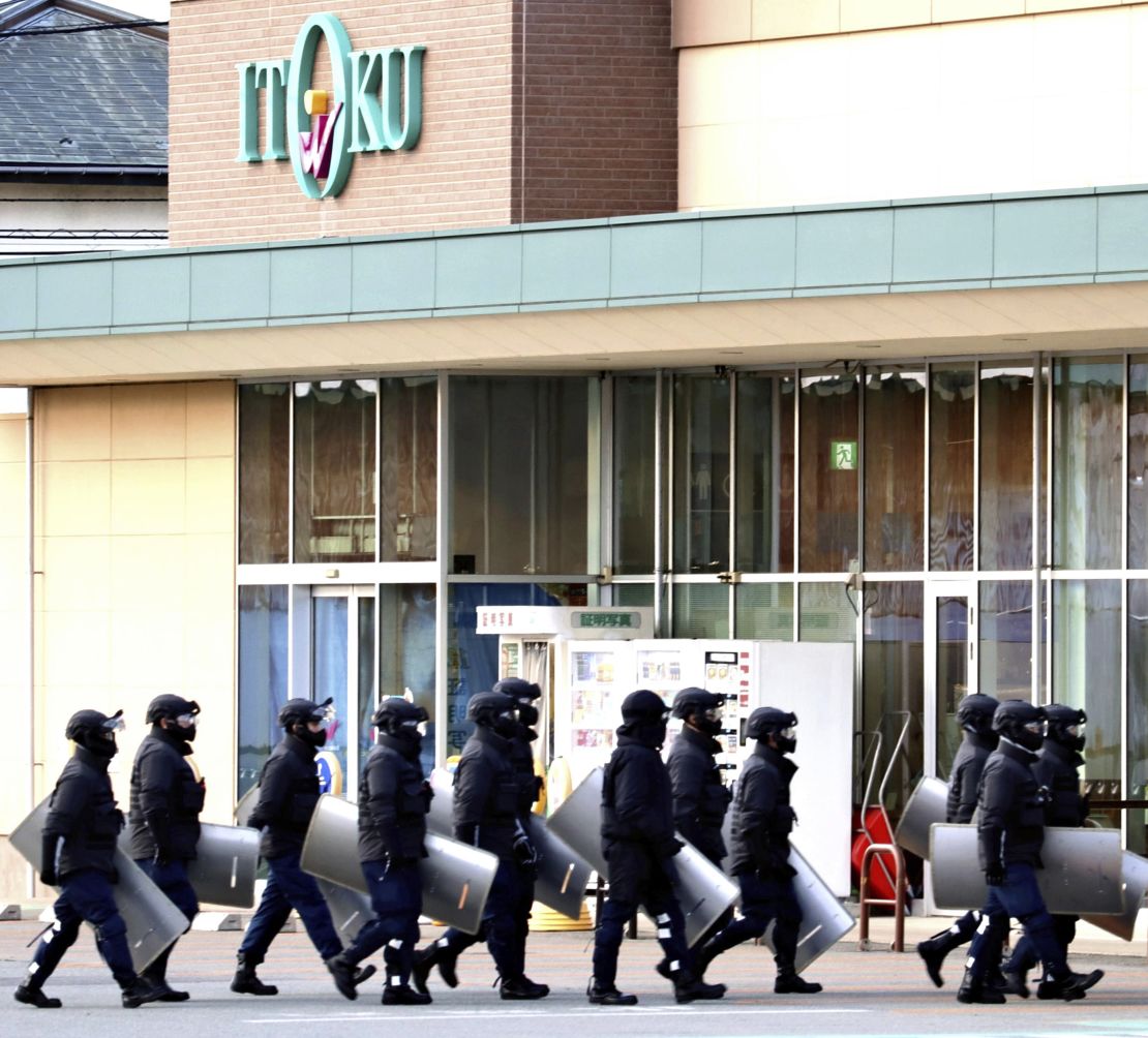 Police officers enter the supermarket to capture the bear in Akita, Japan on December 1, 2024.