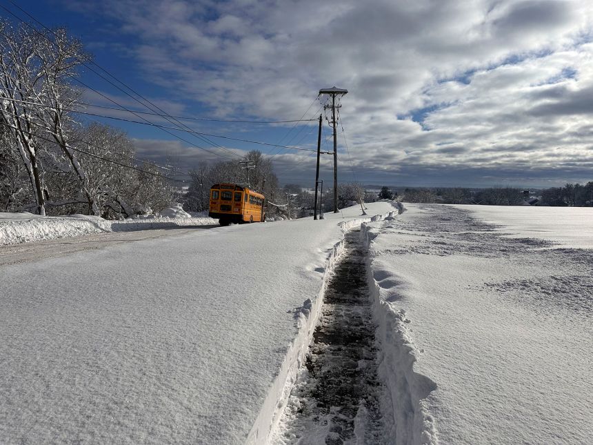 A school bus drives down a cleared road after a snowstorm in Lowville, New York, on Monday, December 2, 2024.