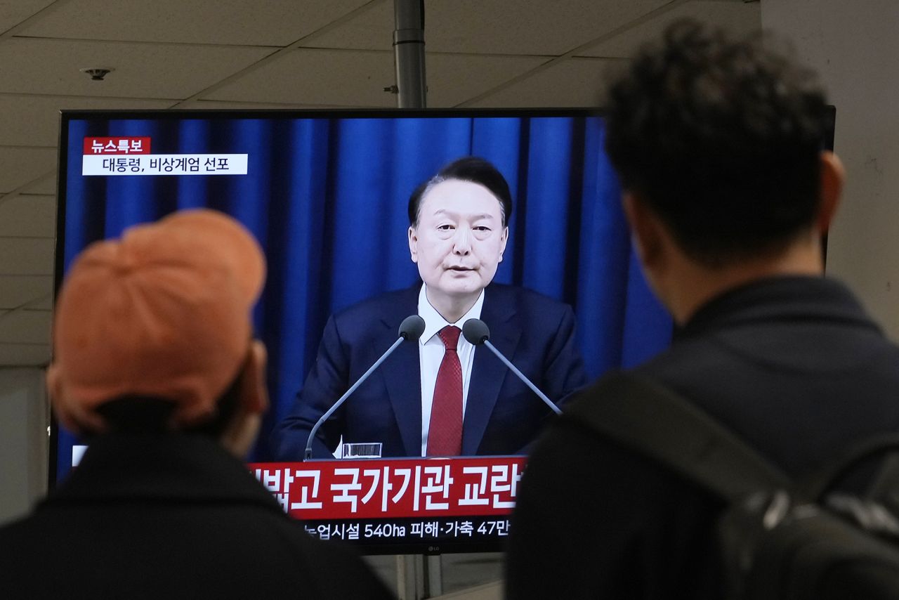 People watch a TV screen showing South Korean President Yoon Suk Yeol's televised briefing at a bus terminal in Seoul, South Korea, on December 3.