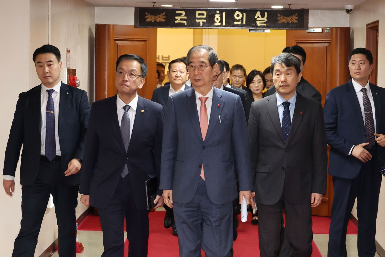 South Korean Prime Minister Han Duck-soo, center, and other ministers leave after a meeting at the government complex in Seoul, South Korea, on December 4.