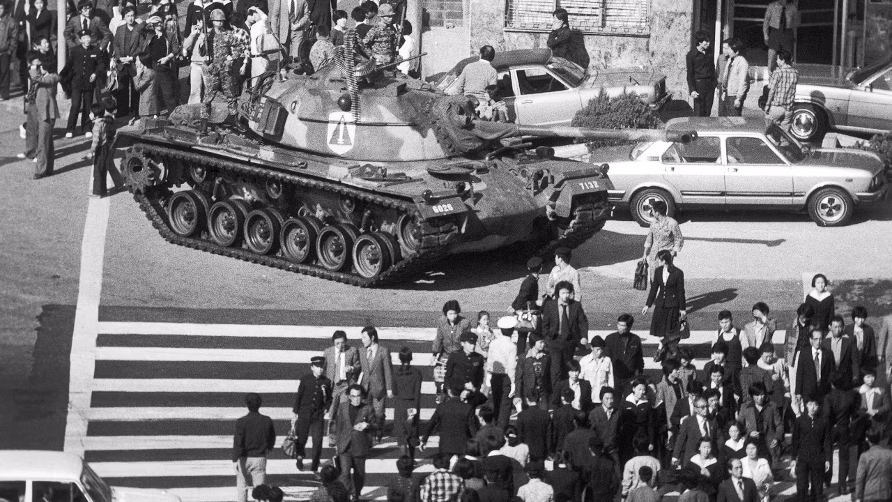 Seoul citizens walk beside an army tank on October 27, 1979, after martial law was declared following the death of President Park Chung-Hee.