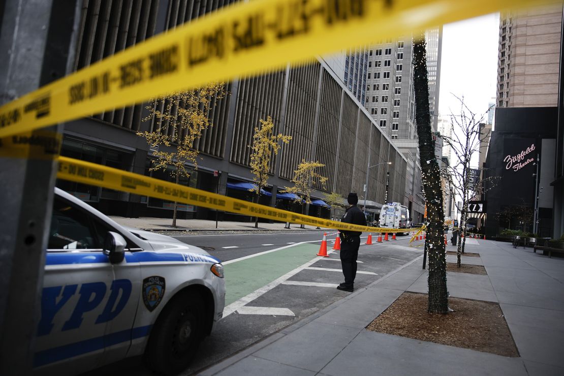 A New York police officer stands on 54th Street outside the Hilton Hotel in midtown Manhattan where Brian Thompson, the CEO of UnitedHealthcare, was fatally shot last week.