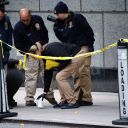 Members of the New York police crime scene unit pick up cups marking the spots where bullets lie as they investigate the scene outside the Hilton Hotel in midtown Manhattan where Brian Thompson, the CEO of UnitedHealthcare, was fatally shot Wednesday, Wednesday, Dec. 4, 2024, in New York. (AP Photo/Stefan Jeremiah)