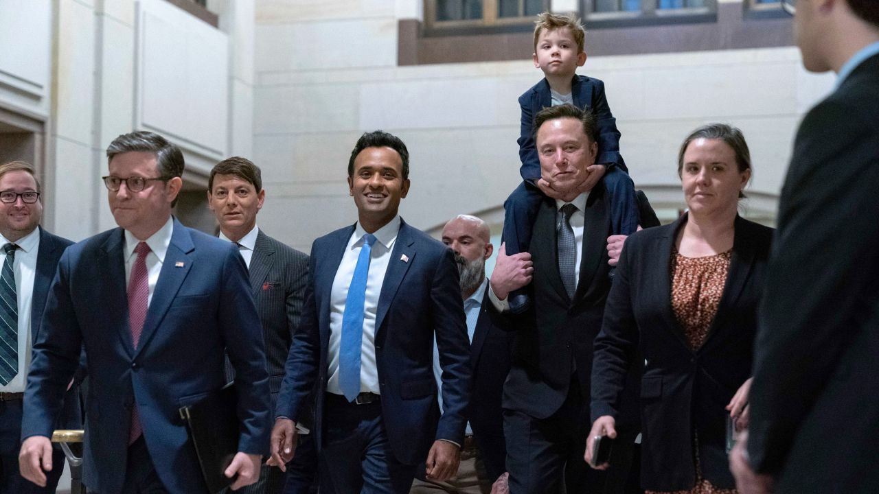 Speaker of the House Mike Johnson, R-La., from left, walks with Vivek Ramaswamy and Elon Musk, who is carrying his son X Æ A-Xii, as they arrive for a roundtable meeting to discuss President-elect Donald Trump's planned Department of Government Efficiency, on Capitol Hill in Washington, Thursday, Dec. 5, 2024. (AP Photo/Jose Luis Magana)