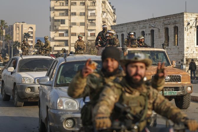 Syrian opposition fighters ride along the streets in the aftermath of the takeover of Hama, Syria, on December 6.