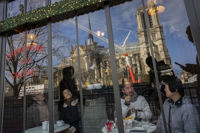 Customers sit inside a restaurant across the cathedral on December 7.