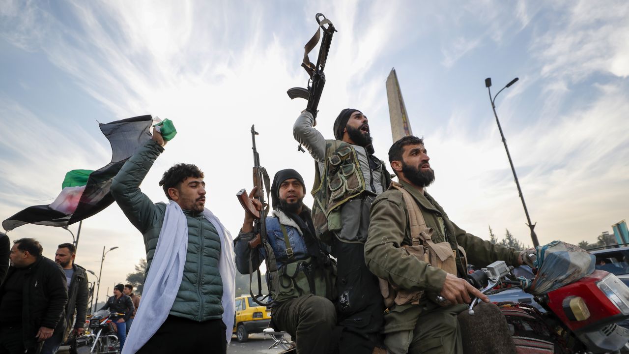 Syrian opposition fighters celebrate after the Syrian government collapsed in Damascus, Syria, Sunday, Dec. 8, 2024. (AP Photo/Omar Sanadiki)