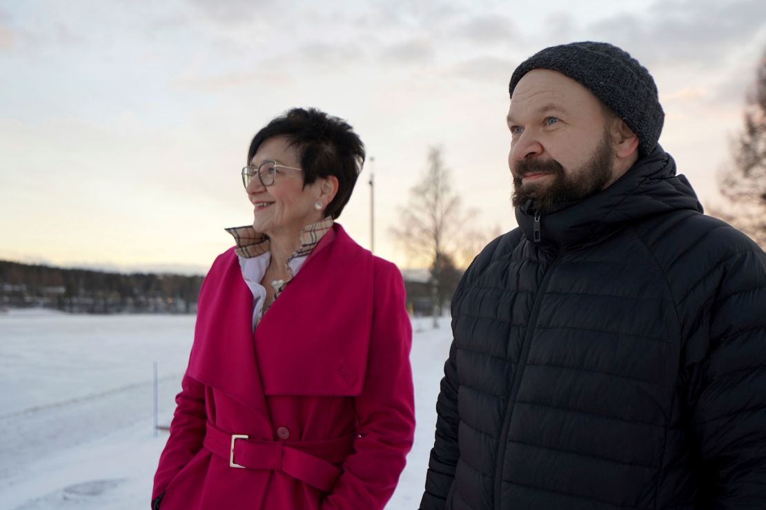 Antti Pakkanen, right, and Taina Torvela, members of a Rovaniemi housing network, stand by the Kemijoki River.