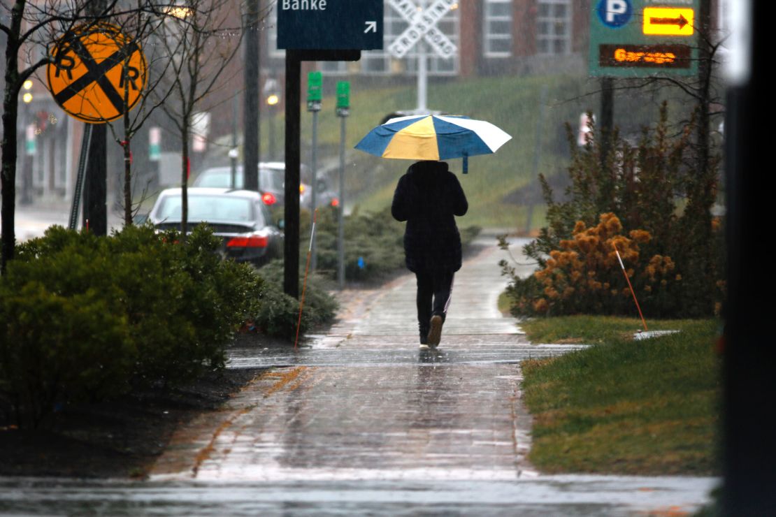 A person walks through the rain in Portsmouth, New Hampshire on Wednesday.