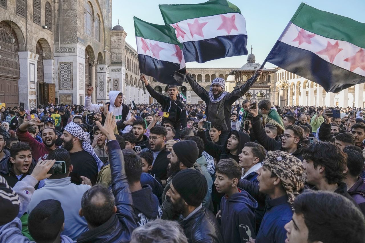 Syrians chant slogans and wave the new Syrian flag as they gather for Friday prayers at the Umayyad mosque in Damascus, Syria, on December 13.