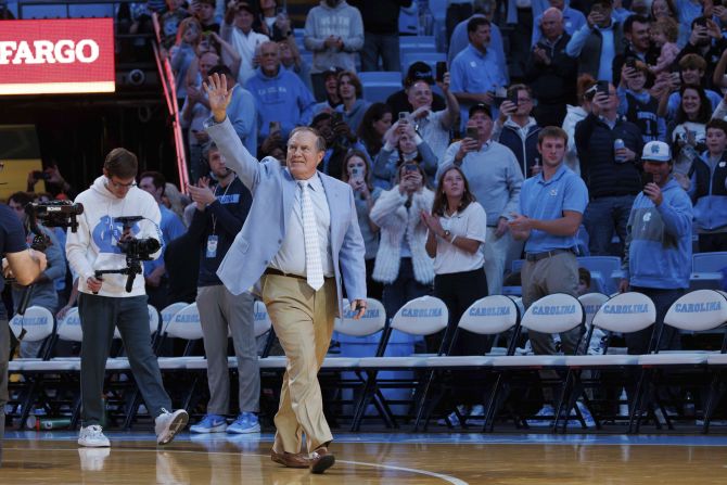 Belichick waves to the crowd during halftime of a UNC basketball game in December 2024.