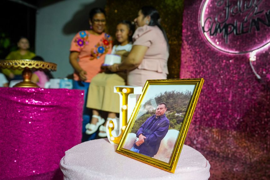 The portrait of murdered environmentalist Juan Lopez is seen in her daughter, Julia Lopez Pena, posing for a photo with her relatives at her family's home in Tocoa, Honduras in December. 7, 2024.