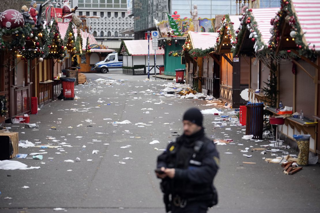 A police officer stands at the cordoned-off Christmas market in Magdeburg on Saturday, a day after the car-ramming attack.