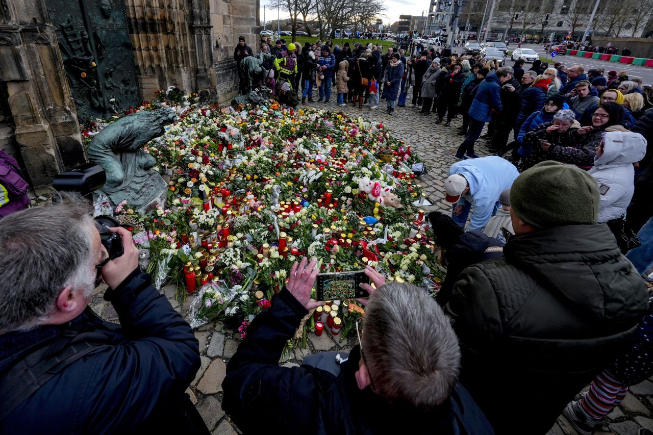 People lay flowers at the entrance of a church near the Christmas market in Magdeburg, Germany, on December 21.