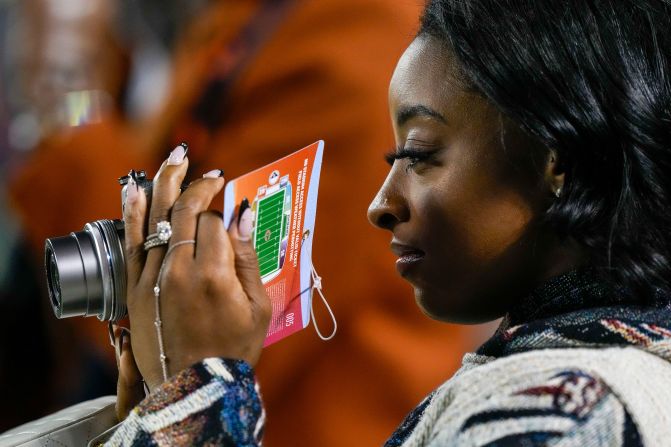 Olympic gymnast Simone Biles uses a camera while watching warmups ahead of the Chicago Bears' game against the Seattle Seahawks in Chicago on Thursday, December 26. Biles <a  target="_top" href="/newspapers?url=https://www.cnn.com/2023/04/22/us/simone-biles-jonathan-owens-married/index.html">married Bears safety Jonathan Owens</a> in 2023.