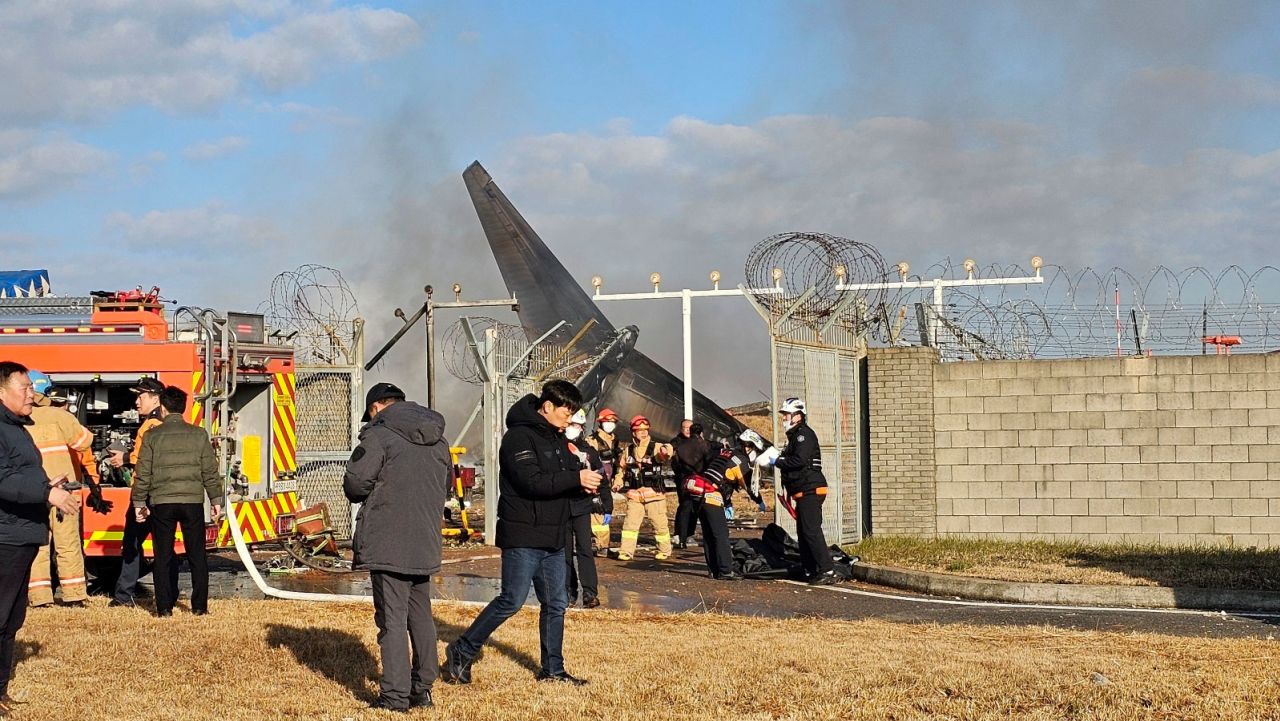 Firefighters and rescue team members work near the crash site.