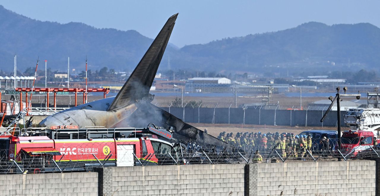 Firefighters and rescue team members work on the runway at Muan International Airport in Muan, South Korea, Sunday.