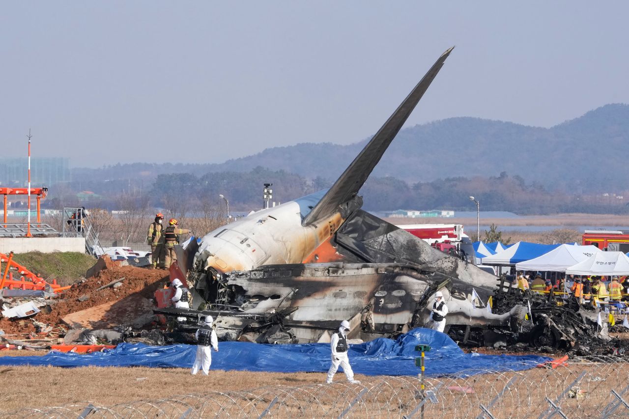 Firefighters and rescue team members work near the wreckage of a passenger plane at Muan International Airport on December 29.