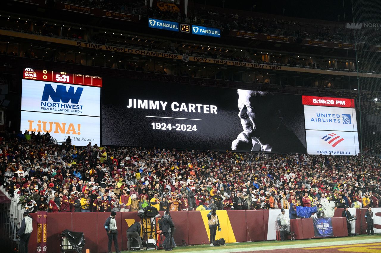 A video tribute to former President Jimmy Carter is seen before an NFL football game between the Washington Commanders and the Atlanta Falcons in Landover, Maryland, on Sunday evening.