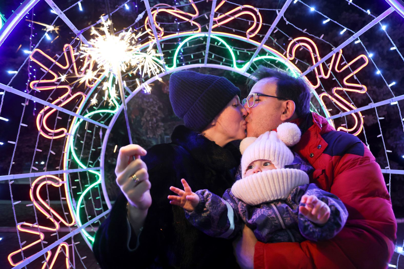 A couple shares a tender moment as they walk with their child in Donetsk, Ukraine.