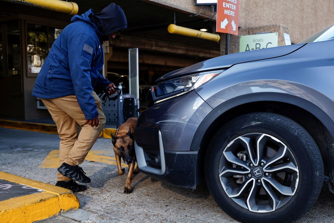 Security and bomb-sniffing dogs check vehicles as they enter the Superdome parking garage ahead of the Sugar Bowl.