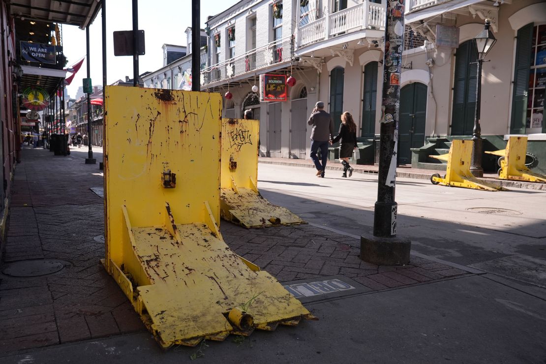 Tourists walk past temporary barriers on Bourbon Street on January 2, one day after the attack.