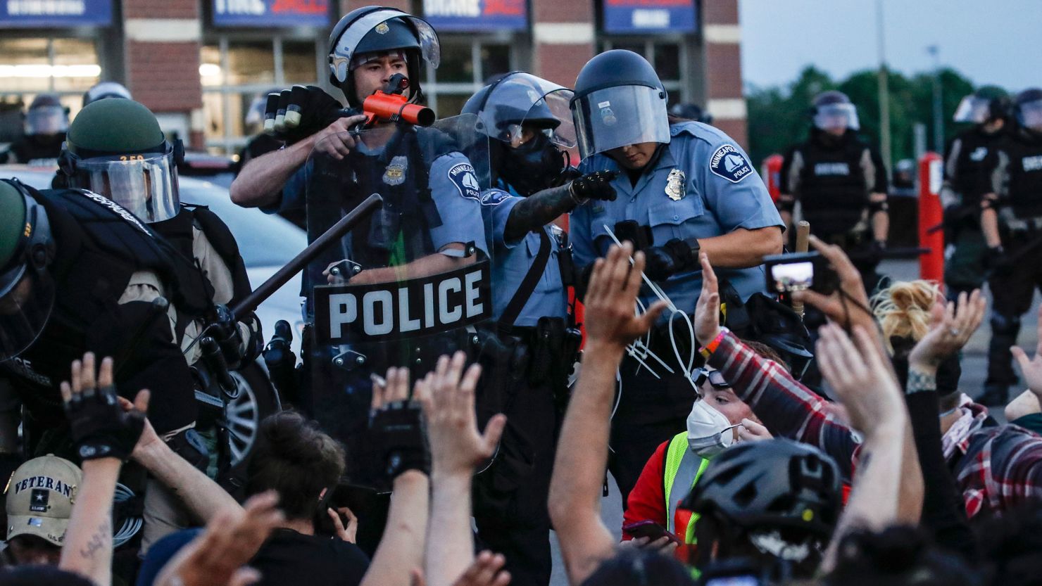 A police officer points a hand cannon at protesters who were detained in Minneapolis on May 31, 2020, during protests following the death of George Floyd.