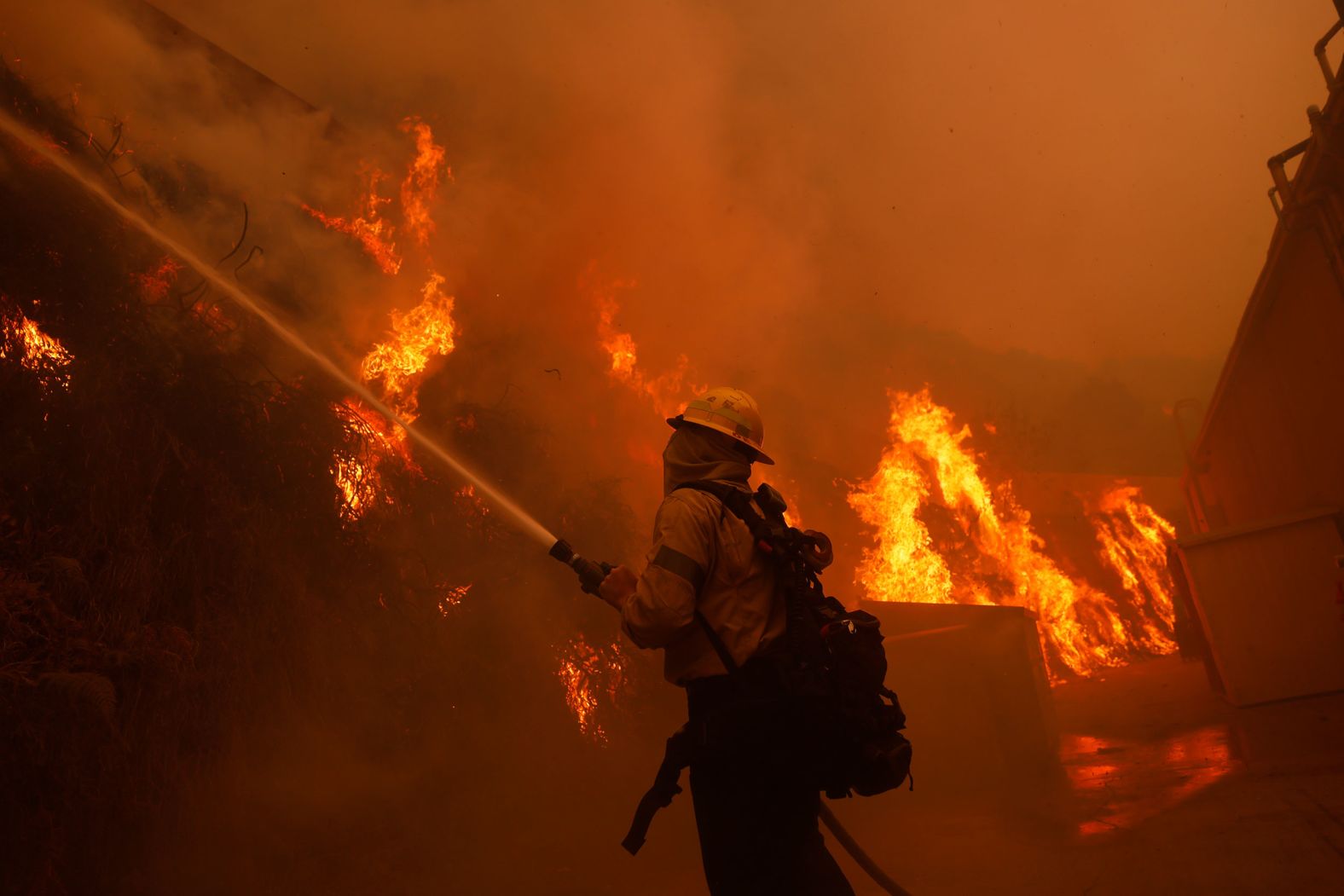 A firefighter battles an advancing wildfire in Pacific Palisades.