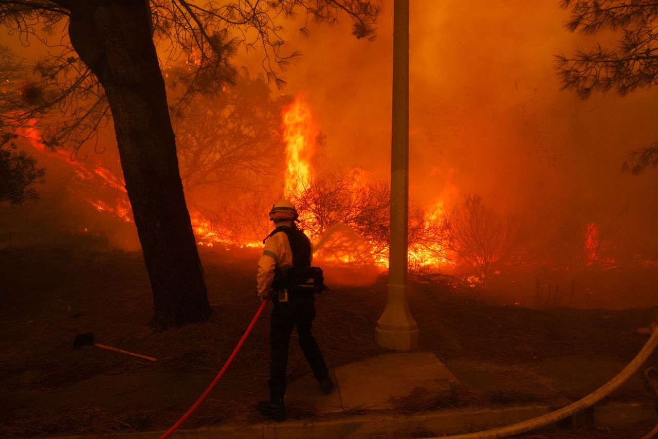 A firefighter battles the advancing Palisades Fire in the Pacific Palisades neighborhood of Los Angeles on Tuesday.