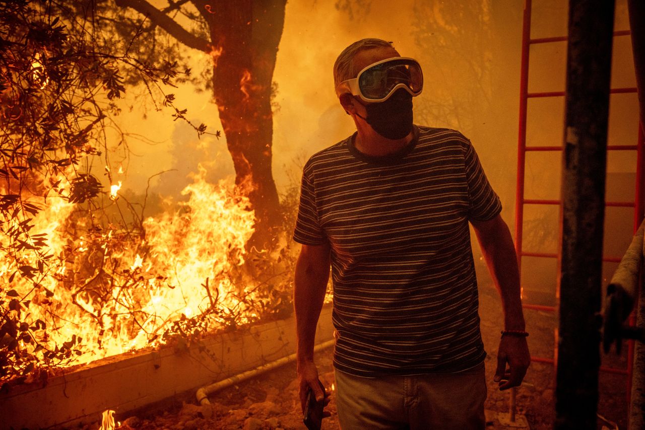 Will Adams watches as flames from the Palisades Fire close in on his property in the Pacific Palisades neighborhood of Los Angeles, on Tuesday.