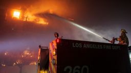 A Los Angeles Fire Department firefighter sprays water on a burning apartment complex caused by the rapidly spreading Palisades Fire in Pacific Palisades neighborhood in Los Angeles, Calif., on Tuesday, Jan. 7, 2025.