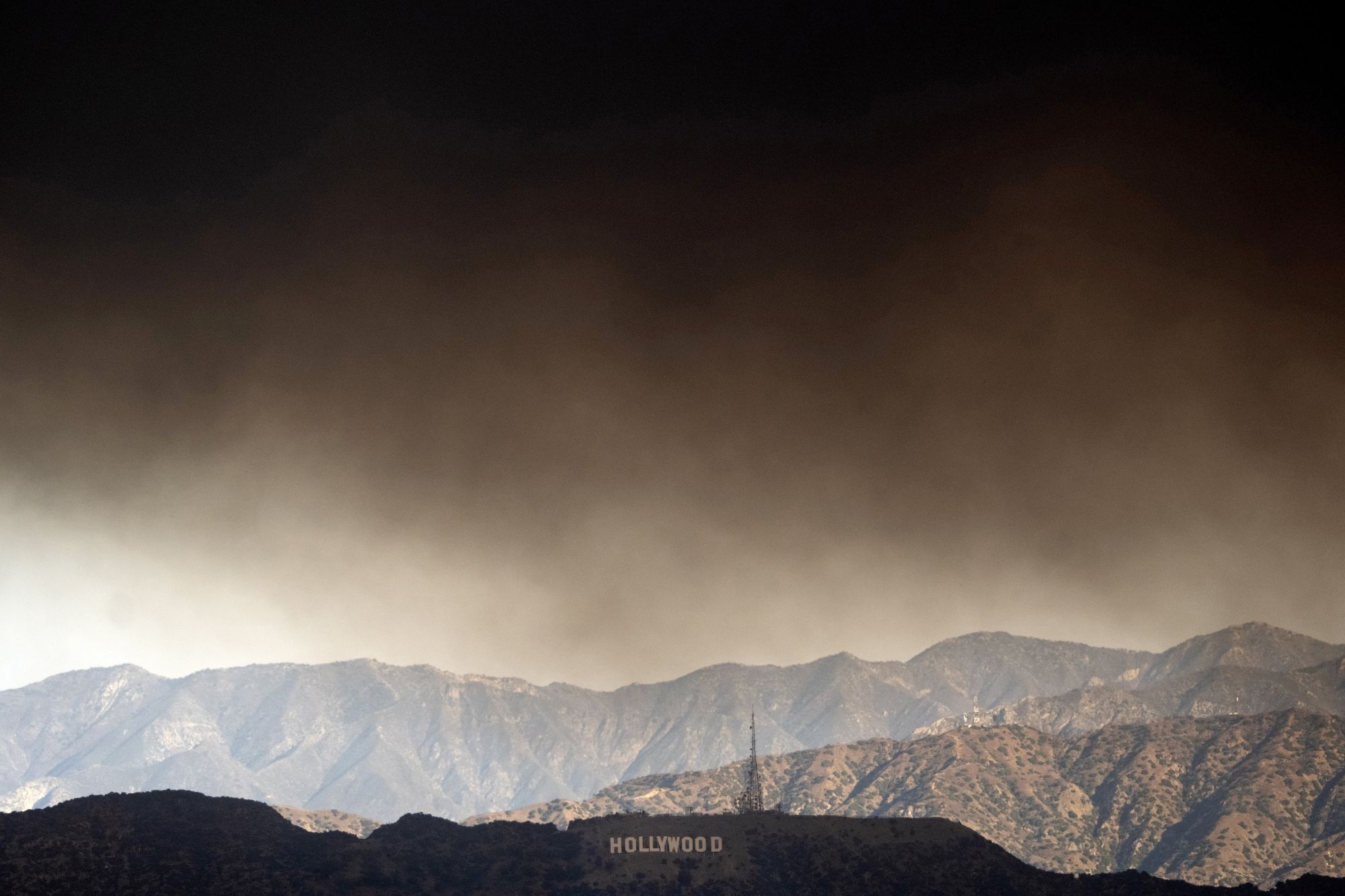 Heavy smoke from wildfires passes over the Hollywood sign in Los Angeles on Wednesday.