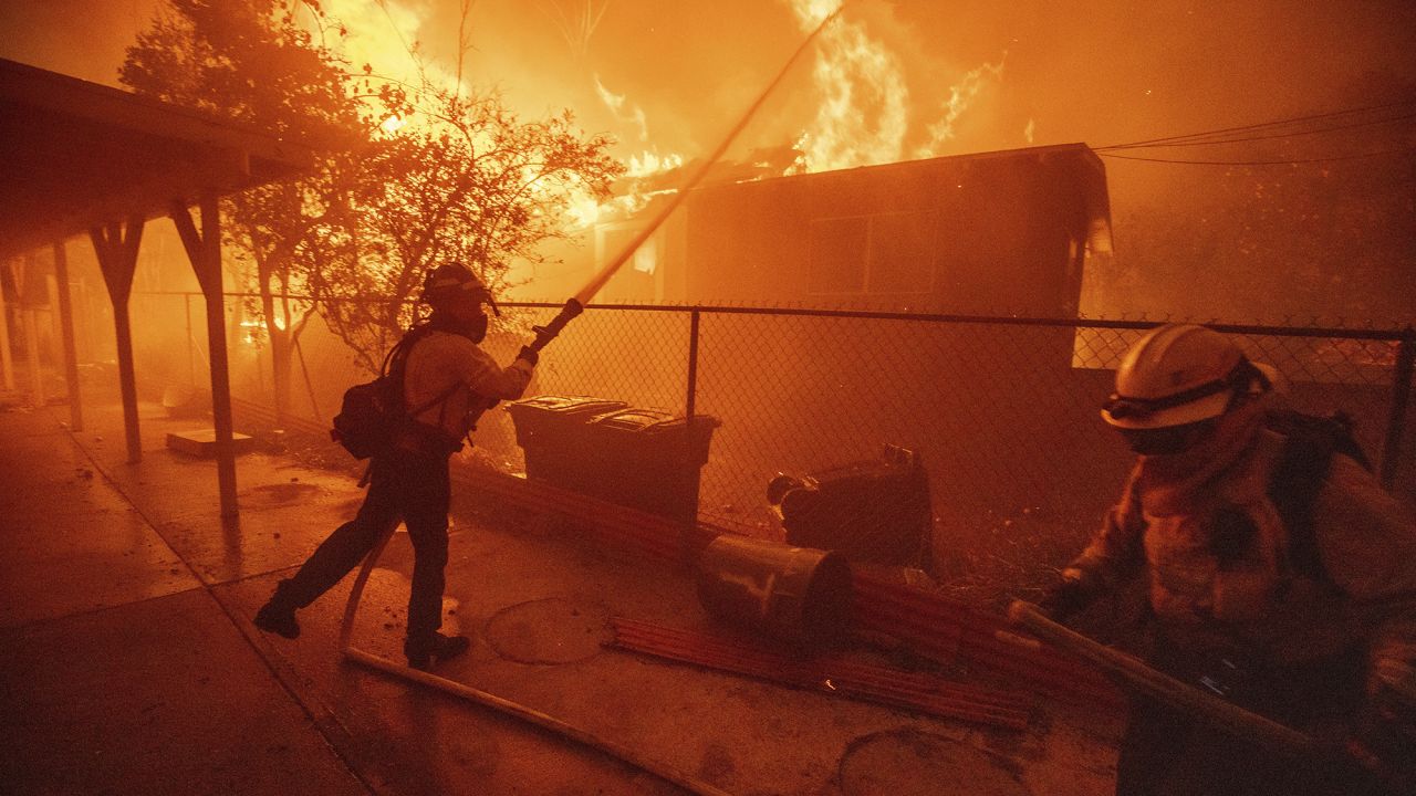 Firefighters protect a structure as the Eaton Fire advances Wednesday, Jan. 8, 2025 in Altadena, Calif.