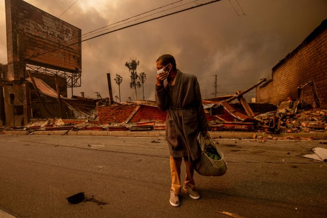 A man walks past an Altadena business ravaged by the Eaton Fire.