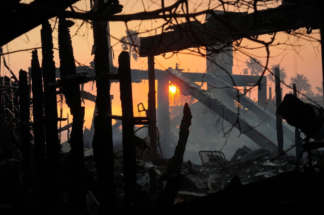 The sun rises behind destruction from the Palisades Fire in Los Angeles on January 9.