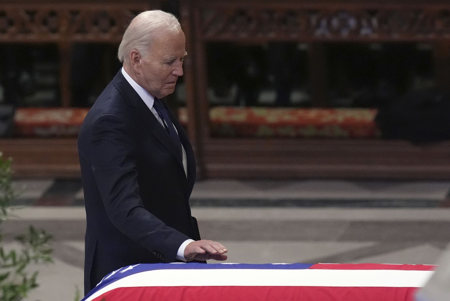 Biden, who gave a eulogy at the funeral, touches Carter's casket.